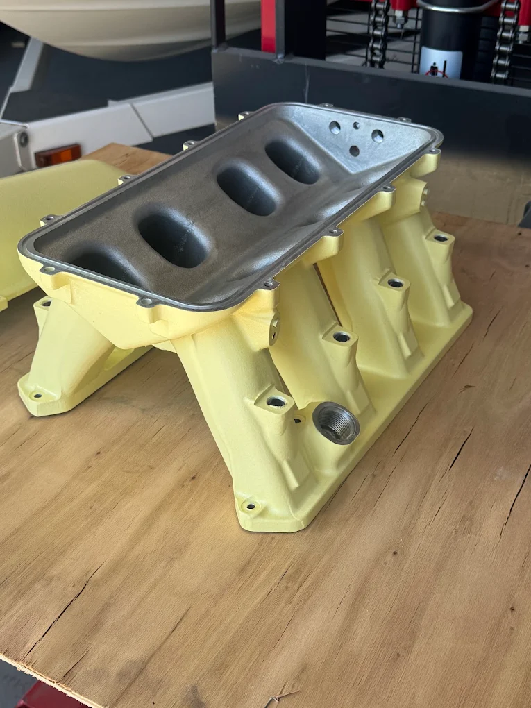 Aluminum intake manifold media blasted and powder coated yellow for a Ithaca, MI customer